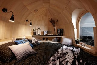 Inside, the cabins are wrapped in either aspen or spruce, with most of the timber sourced sustainably from Estonian forests. The same shingling technique used on the exterior is employed to create a layered, half-dome design at each end of the hut.