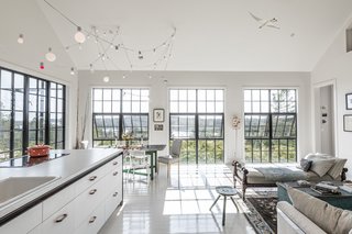 All the kitchen cabinets and appliances are consolidated into one island. Both the island and light fixture were designed by Berman Horn Studio. The countertop is by Abet Laminati.