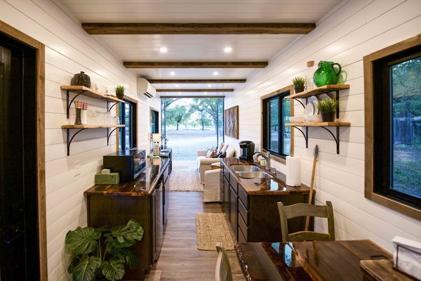 Inside, the team thinly frames the walls for insulation, plumbing and electrical, and finishes the space off with wood paneling, custom cabinetry, and full-sized fittings.