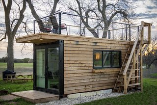 Exterior, Flat RoofLine, Tiny Home Building Type, Prefab Building Type, Wood Siding Material, and Shipping Container Building Type CargoHome specializes in building tiny homes using single-trip shipping containers arriving in the United States from China. Glimpses of the steel structure remain visible around the facade—including the original container doors, which are carved out and inset with new glass panels.