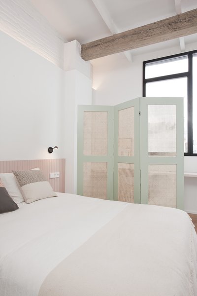 The master bedroom features a pencil-and-acrylic work by Geoff McFetridge and a Vibia sconce.