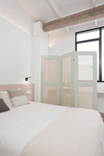 The master bedroom features a pencil-and-acrylic work by Geoff McFetridge and a Vibia sconce.