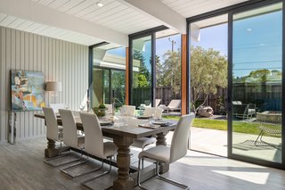Dining Room, Table, Chair, Bar, Vinyl Floor, and Ceiling Lighting The formal dining area is located on the opposite side of the fireplace. A pair of sliding glass doors open to the backyard while accentuating the post-and-beam design.