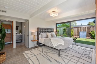 Bedroom, Lamps, Bed, Night Stands, Vinyl Floor, and Ceiling Lighting A look at the master suite, which includes an expansive sliding door that opens to the side yard. The master bathroom features Italian Carrara marble counters and a rain shower.