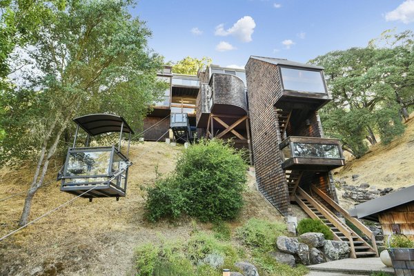 From the base of the hillside, a cable car and staircase lead up the multi-level residence. The current owners commissioned architect John Nance to build the home in 1981 after spending several years finalizing a design that would maintain the natural topography without grading.