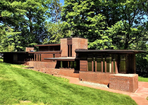 A front view of the home shows the long, horizontal orientation. The home was designed