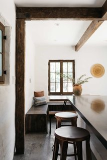 The rear of the kitchen features a dining area with built-in seating.