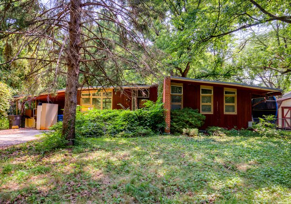 Before, the front facade was largely hidden behind overgrown buses. The renovation retained the original redwood siding.