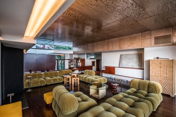 Commissioned in the late 1930s by S.T. and Pauline Falk, the Falk Apartments building offers five units—including the multi-level penthouse shown here. An original plywood ceiling runs through the center of the unit, while mahogany built-ins fill various alcoves and corners.