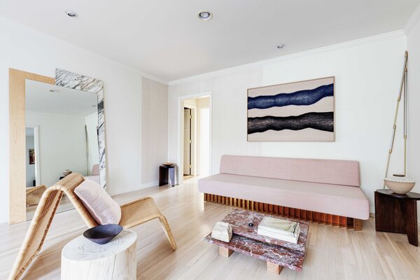 A spacious living area anchors the center of the home; a hallway leads to the bedrooms and bathroom.