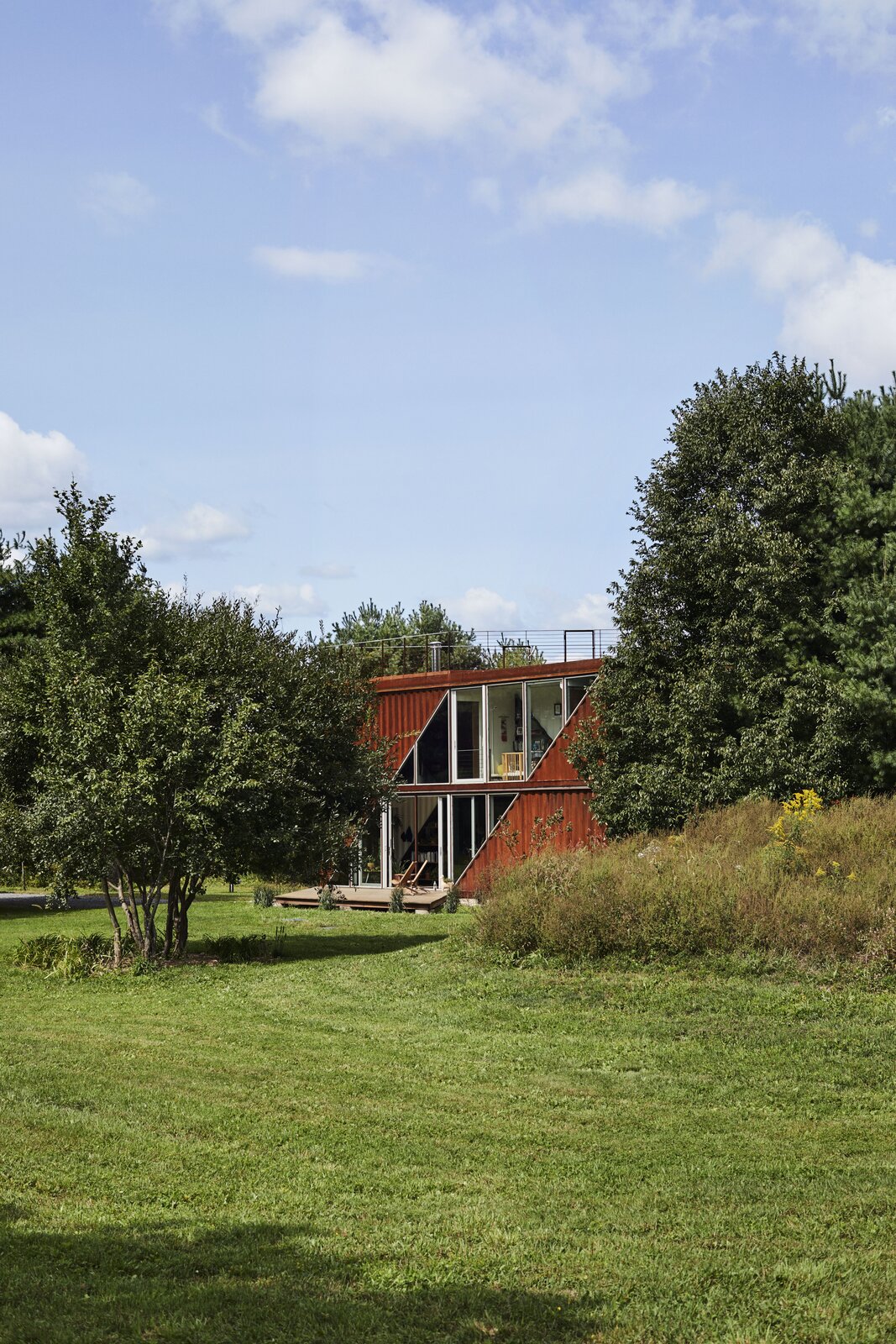 The ruddy Cor-Ten facade contrasts with its verdant surroundings.