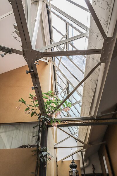 A metal frame design spans across the penthouse, connecting the large, open living spaces. Expansive windows span across the home's high ceilings, drawing in plenty of natural light.