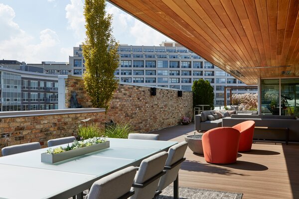 This penthouse apartment in Chicago comes with a dreamy rooftop that is clad in TimberTech AZEK capped polymer decking. An expansive overhang provides shade for the dining area and outdoor kitchen.