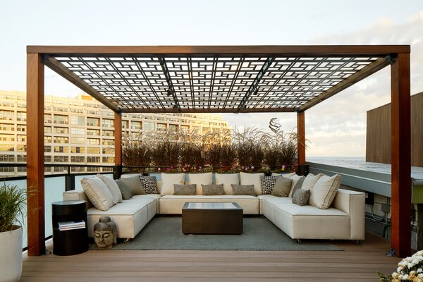 Along the opposite side of the rooftop, a seating area is topped by a large pergola. TimberTech’s composite boards are manufactured using a multi-stage color blending system that adds subtle highlights and low-lights to convincingly recreate the look and feel of real wood.