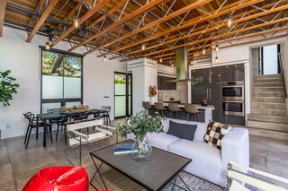 Polished concrete floors run throughout the main level, complementing the tall, wood-clad ceilings with tongue-and-groove detail. The open kitchen boasts Italian lacquer cabinets.