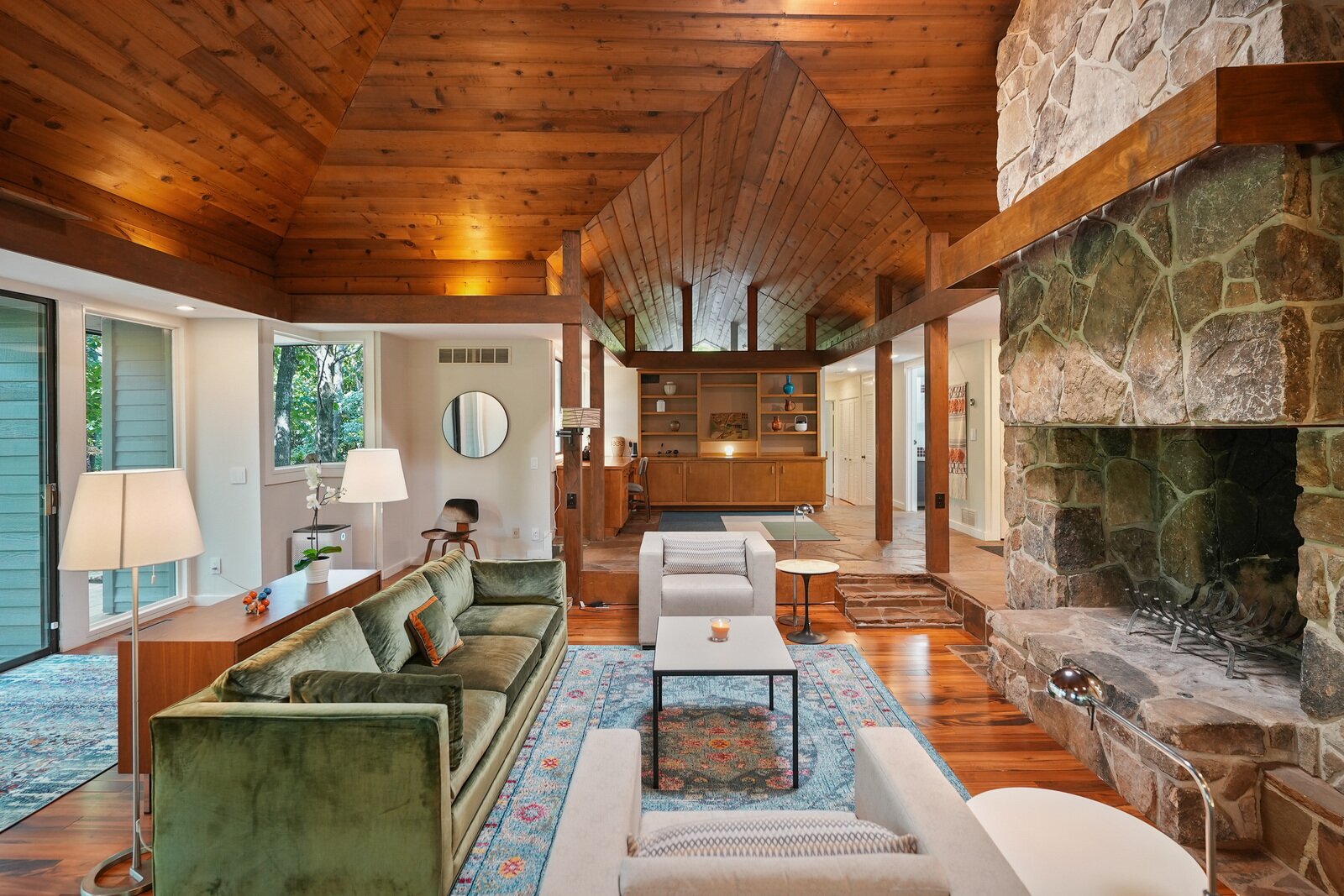 In the living room, recessed lighting is used to emphasize the original wood-clad ceilings.