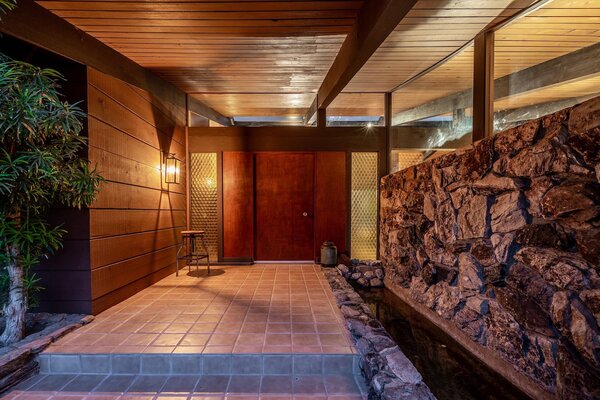 Rucker designed the exterior with stone, wood, and glass as a way to more seamlessly blend the property into its spacious corner lot. The koi pond at the front entrance hints at nature inside.