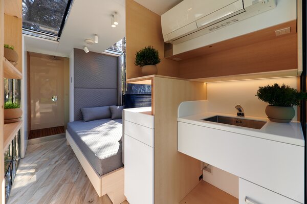 Inside, the small dwelling presents a sun-kissed atmosphere, complete with extensive glazing.