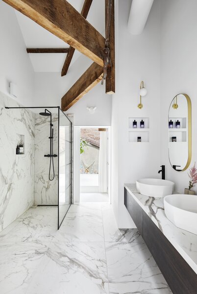 A marble-clad bathroom joins the bedroom and overlooks the skylit living area below.