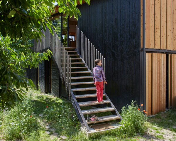 The couple's son, Nathan, outside the home, which is partially covered in wood cladding from Birka DC.