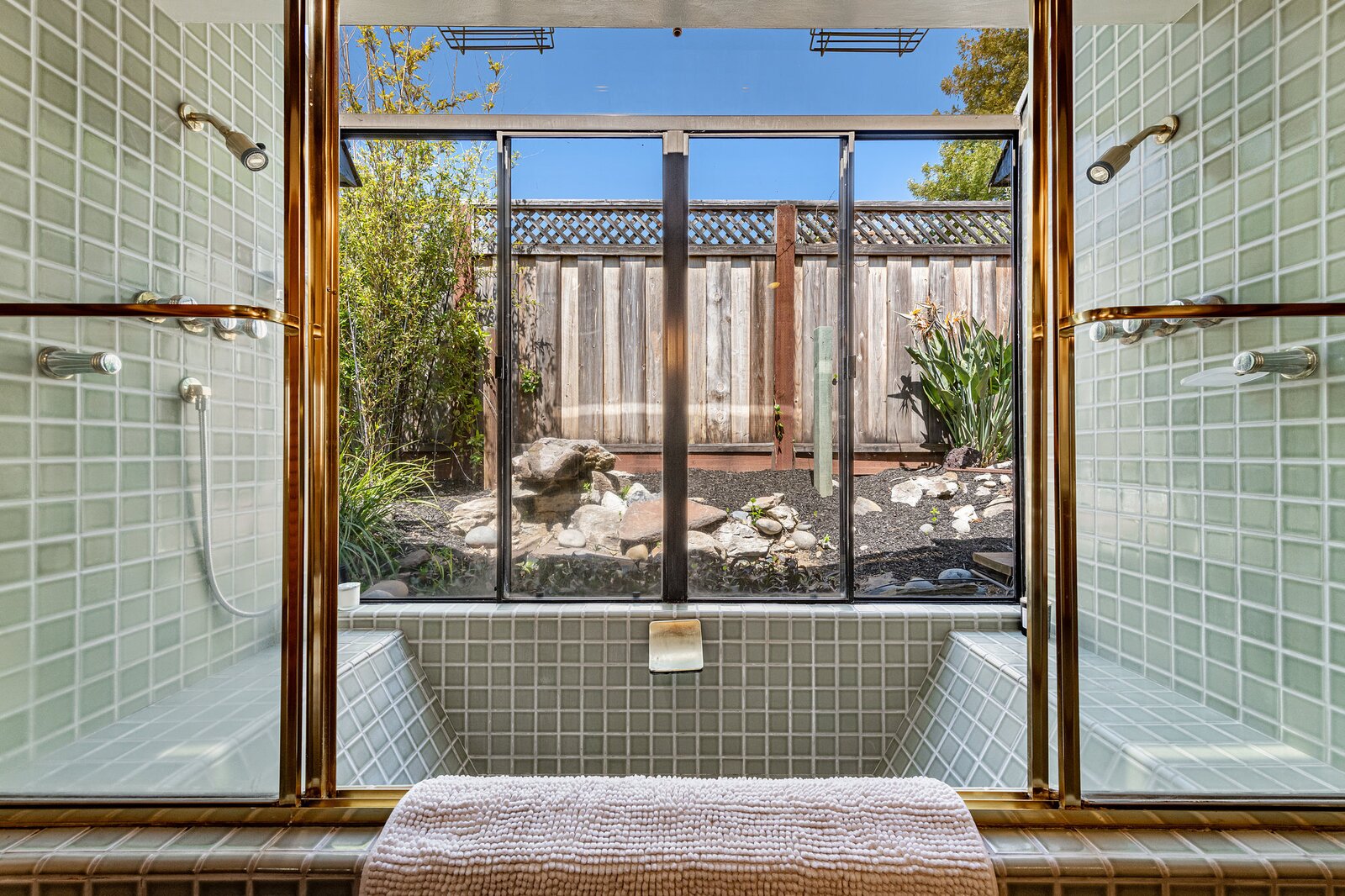 A tiled soaking tub and double shower overlooks the fenced-in side yard.