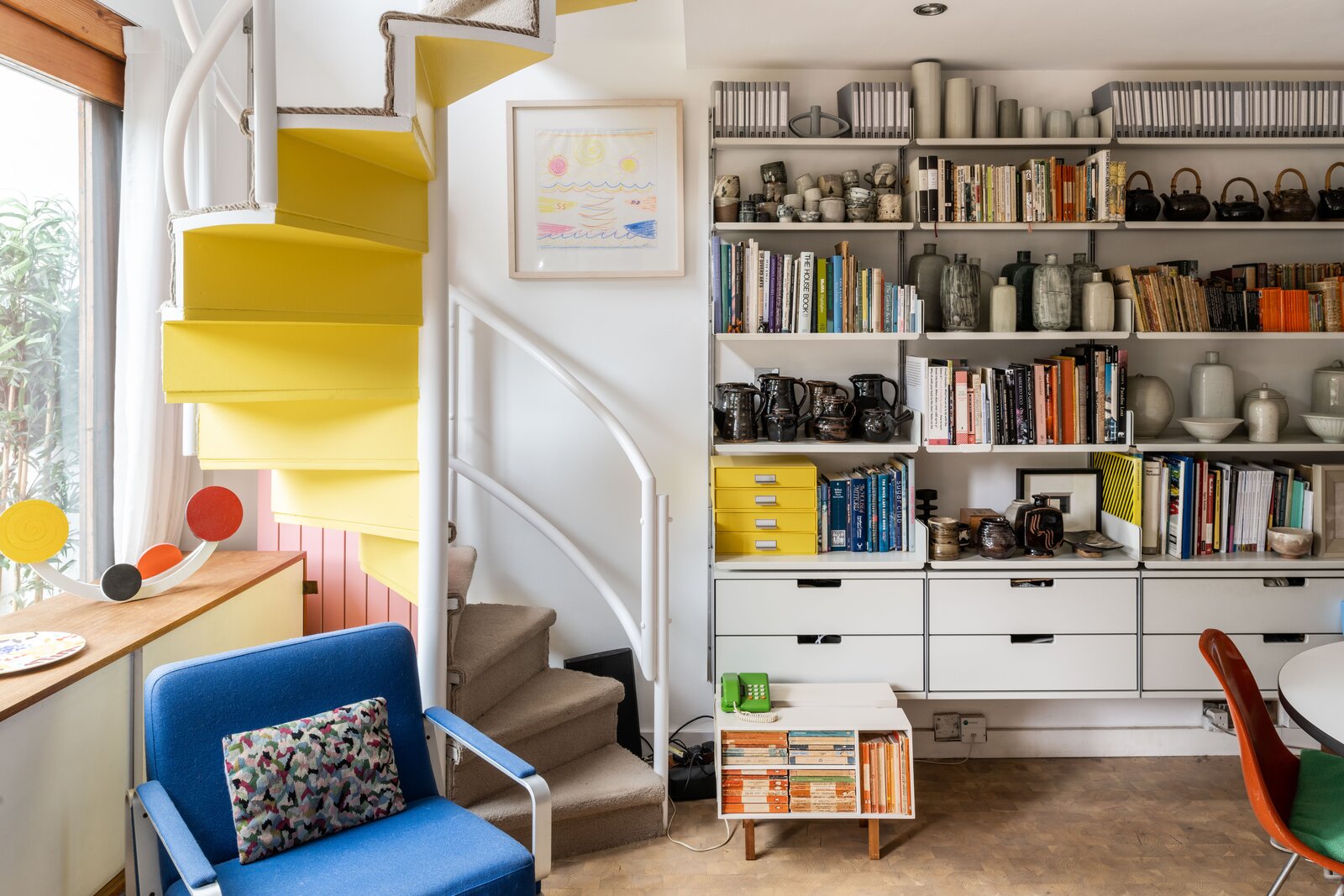 In smaller abodes, spiral staircases are a practical way to access the second floor without taking up too much space. This studio apartment designed by Douglas Stephen &amp; Partners was built in 1965 and has undergone an upgrade in recent years. With a compact, playful look, the bright yellow underside of this spiral staircase brings a bit of fun into a split-level in London, England.