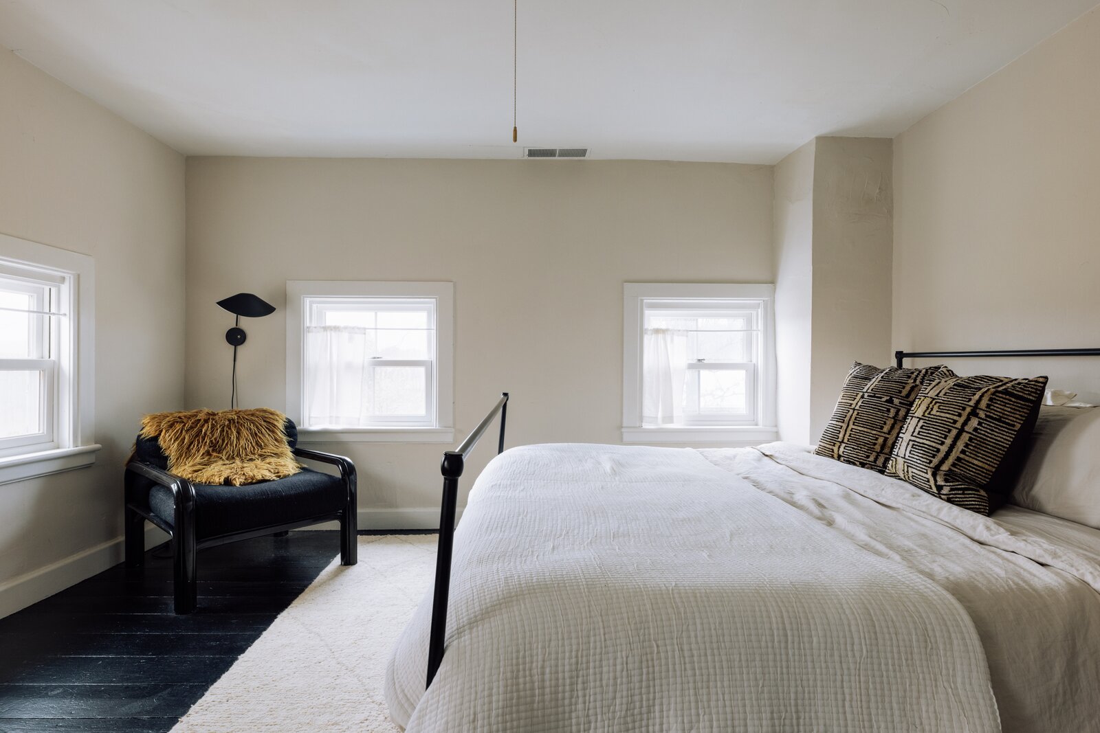 This chair and fluffy yellow pillow add an extra pop to this neutral space.