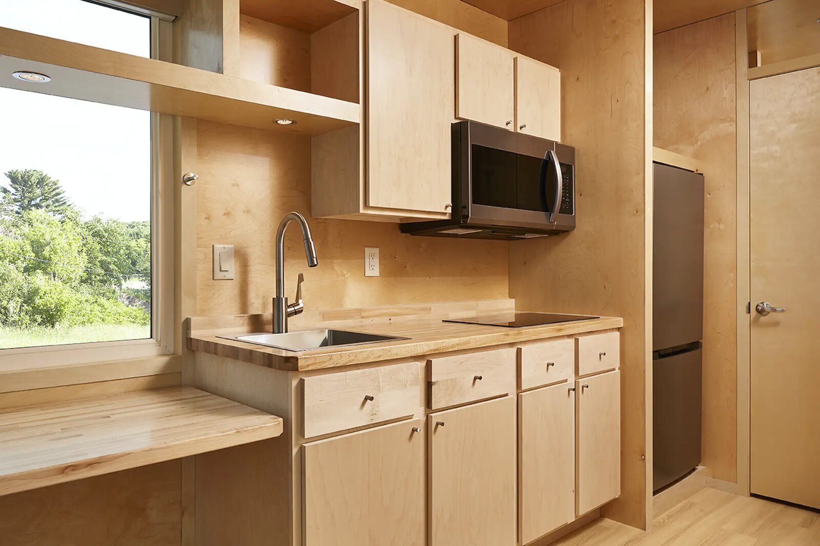 The three home designs, created by Architect Kelly Davis with a Scandi-modern aesthetic, are insulated with Greenguard gold-certified recycled materials, capped with steel roofs, and clad with sustainably grown rough-sawn wood siding with a dark stain. Inside, floor-to-ceiling white birch makes for bright, warm, and textured interiors. 