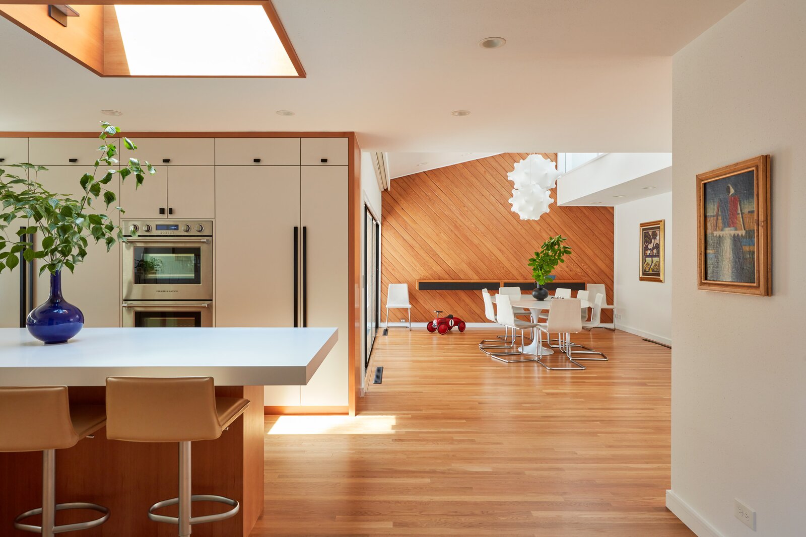 Inside, Graff restored cedar planking and added new walls and floor panels. The kitchen features fresh Fisher &amp; Paykel appliances, while an original slanted wood wall with a built-in credenza defines the dining room. 