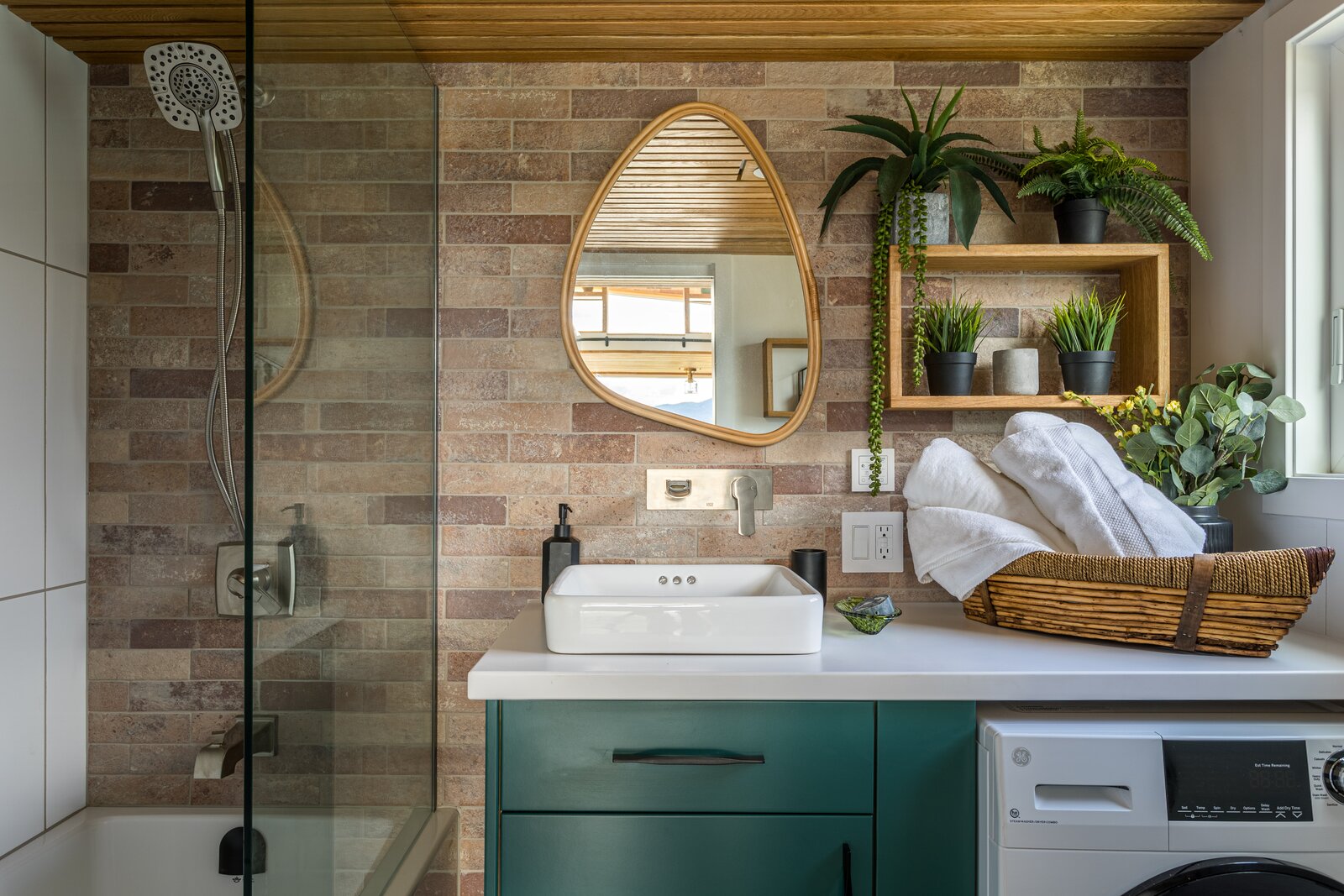 Stainless steel fixtures are installed in the bathroom. The brickwalls at both ends of the tiny home.