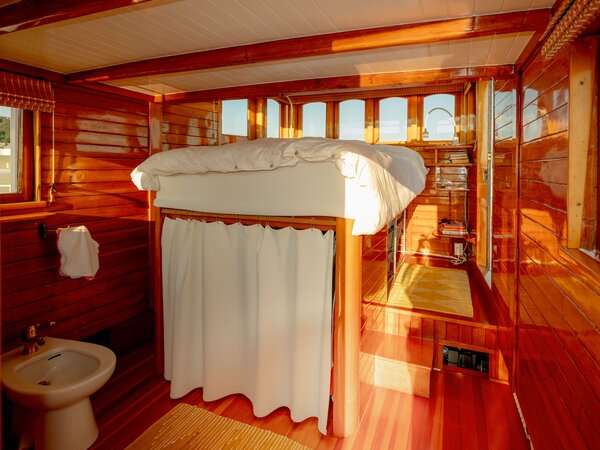 Reached by a step in its platform, the couple’s bed has a seafaring view.