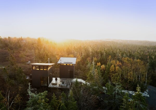 Greg Knapp and Robyn Traynor worked with architect Peter Braithwaite to design a nature retreat for their family on a slice of Canadian wilderness. It has two shed-roofed structures joined by a boardwalk elevated above a preexisting walking path on the couple’s land.