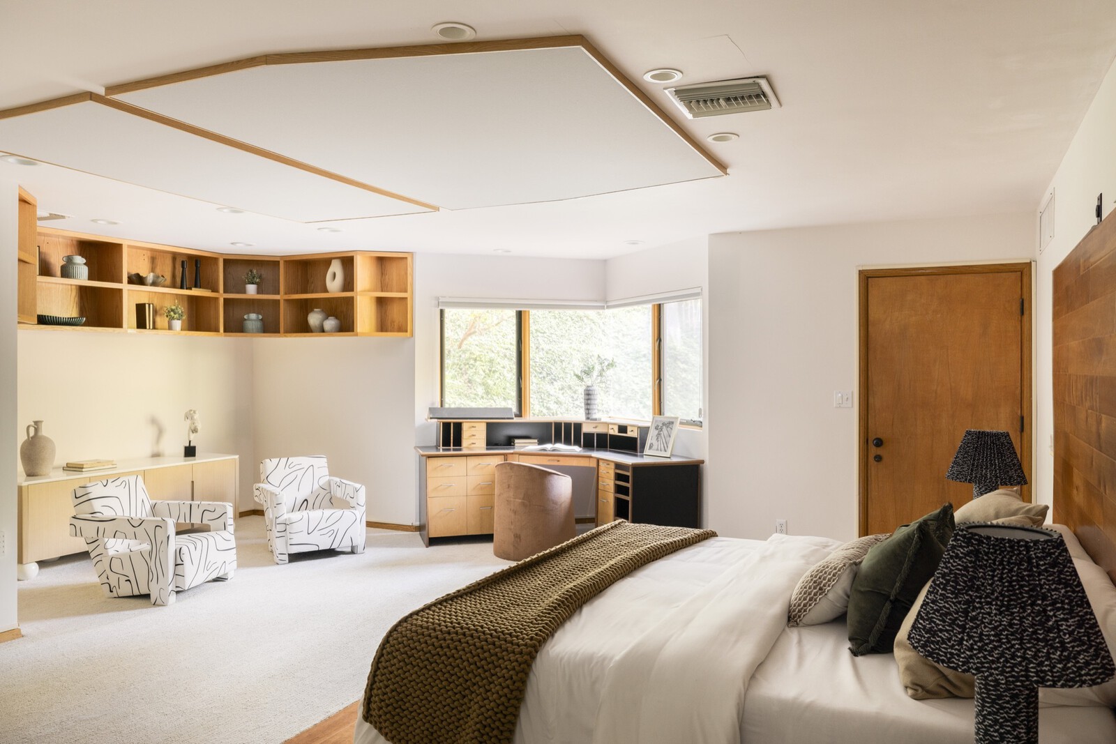 The spacious primary bedroom includes an ensuite bath, walk-in closets, a corner desk area, as well as a private patio connected to the backyard.