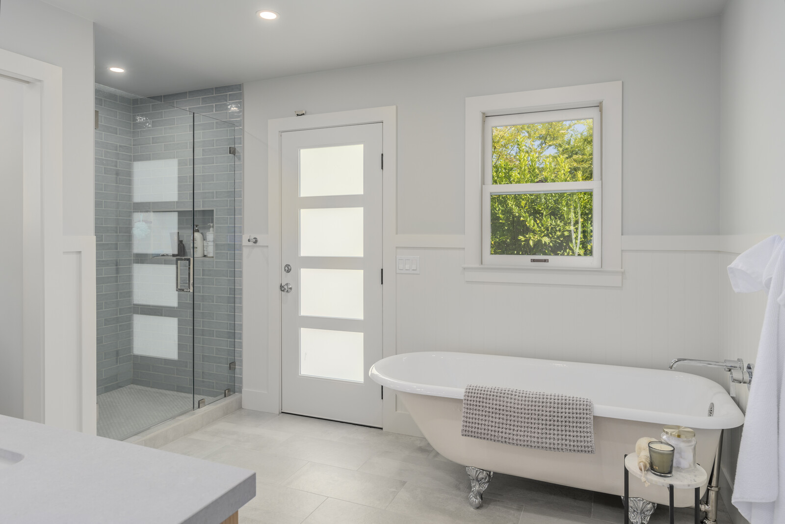 In addition to a large clawfoot tub and glass shower, the primary bath offers outdoor access.