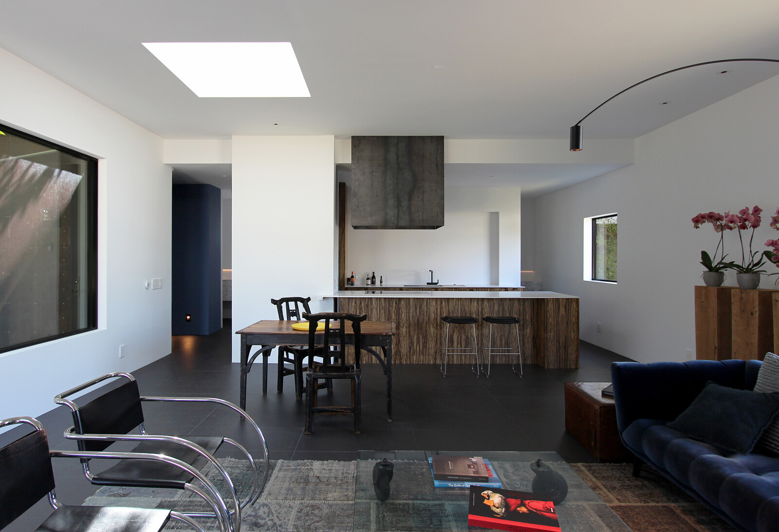 Picture windows and skylights dot the living areas, ensuring ample sunshine sweeps inside. Custom wooden cabinetry in the galley-style kitchen pops against the crisp white walls.