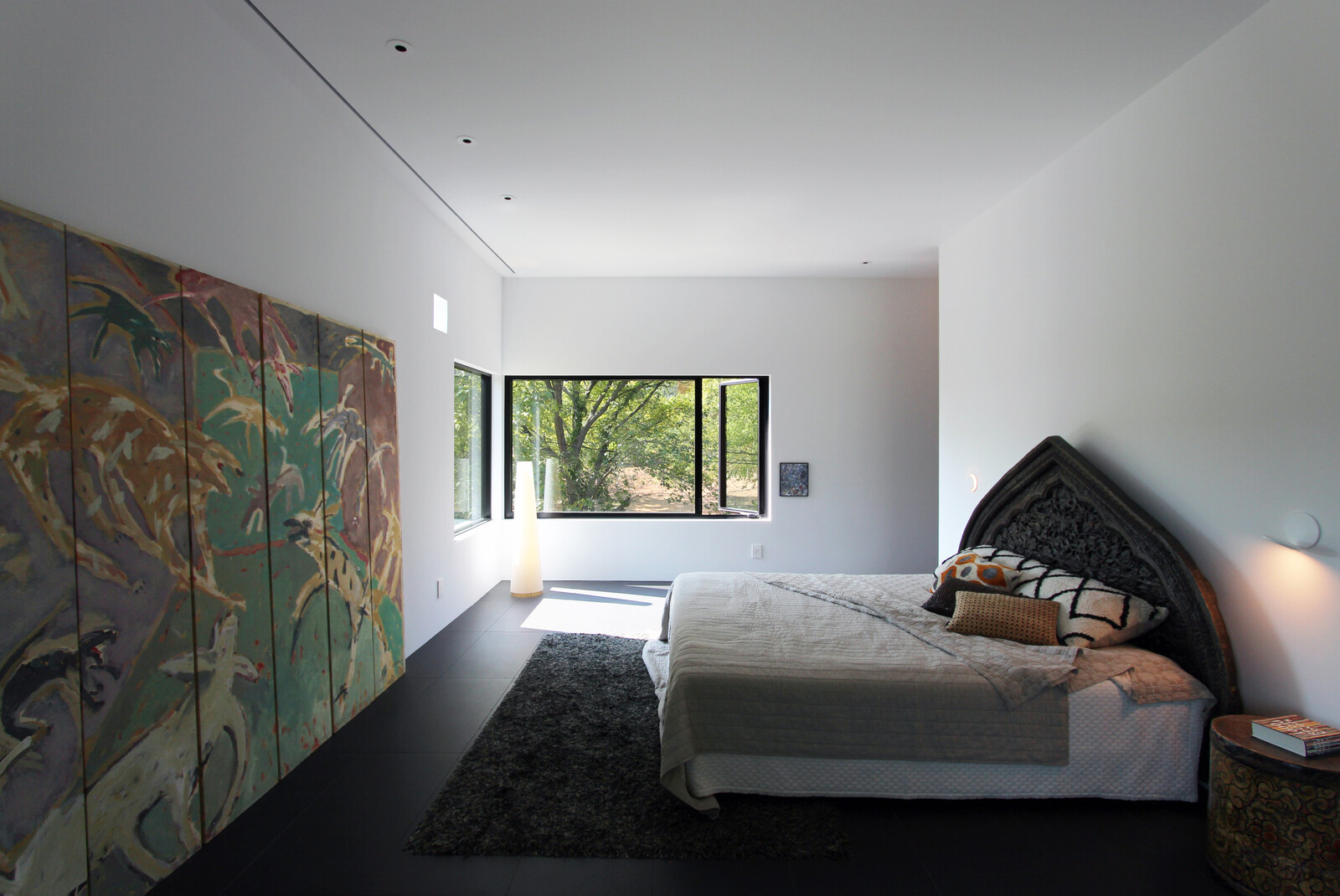 The primary bedroom presents a soothing retreat for relaxation, complete with an oversized soaking tub in the en suite bath. Corner glazing frames striking views of the city skyline.