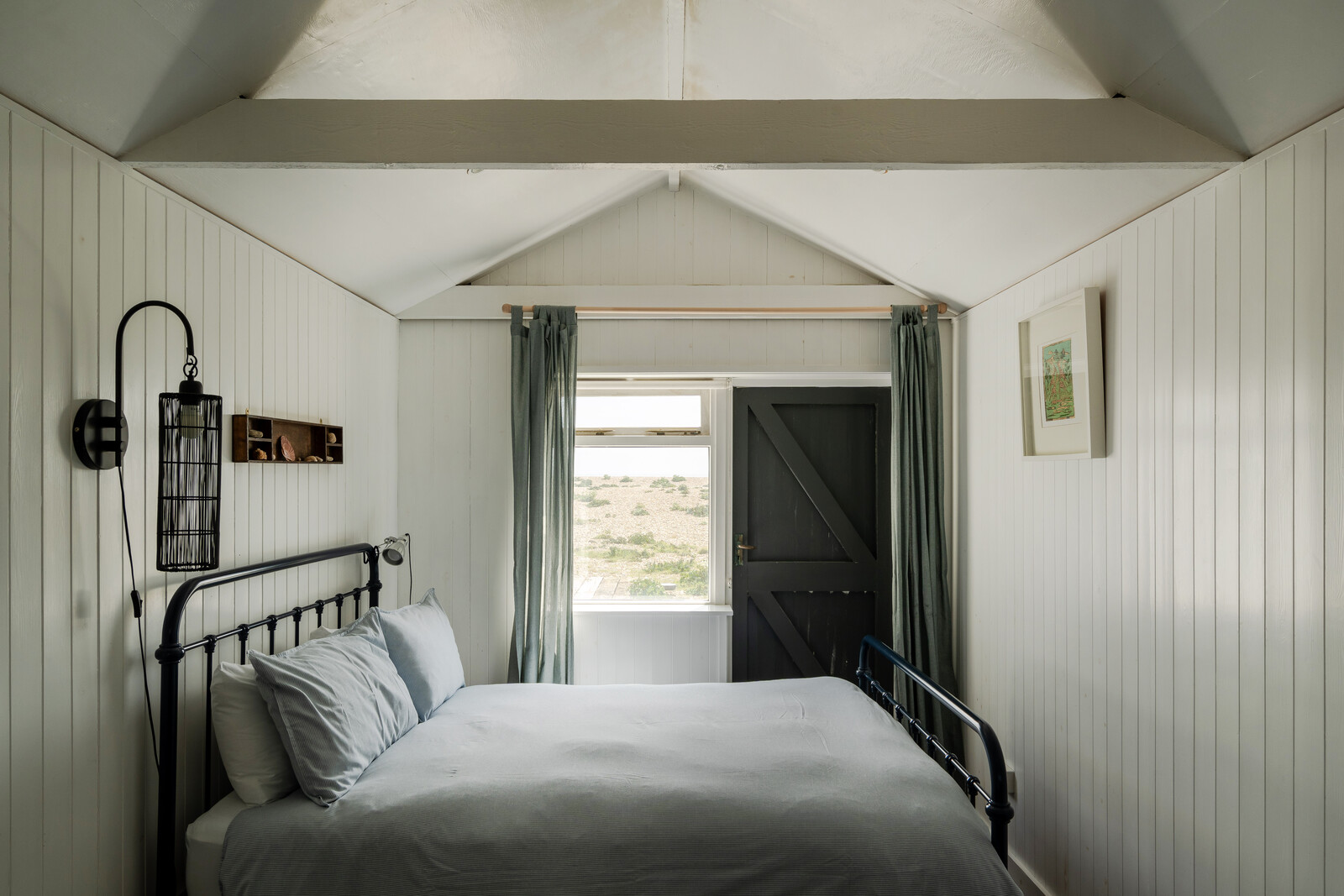 In addition to uninterrupted views toward the sea, the primary bedroom offers an en suite bath and is capped by a tall vaulted ceiling.