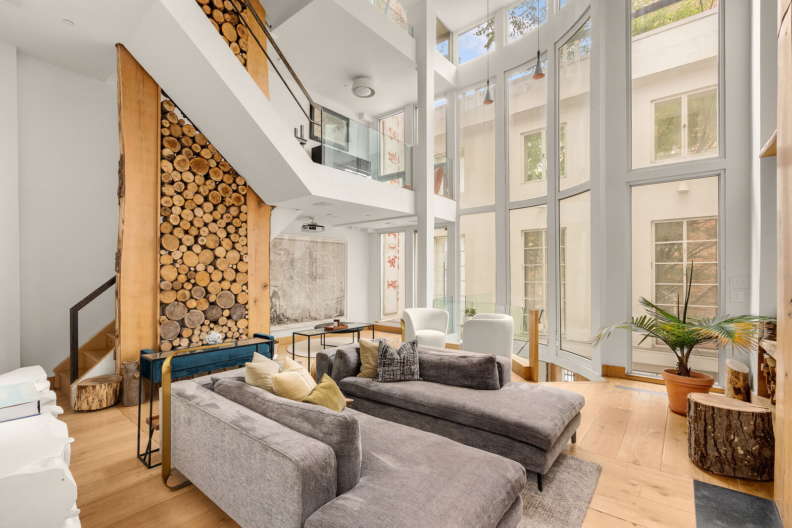 The main living room features 23’ high ceilings and two fireplaces framed by timbers taken from the Hudson Valley. Floor-to-ceiling windows ensure ample sunlight fills each of the three levels.