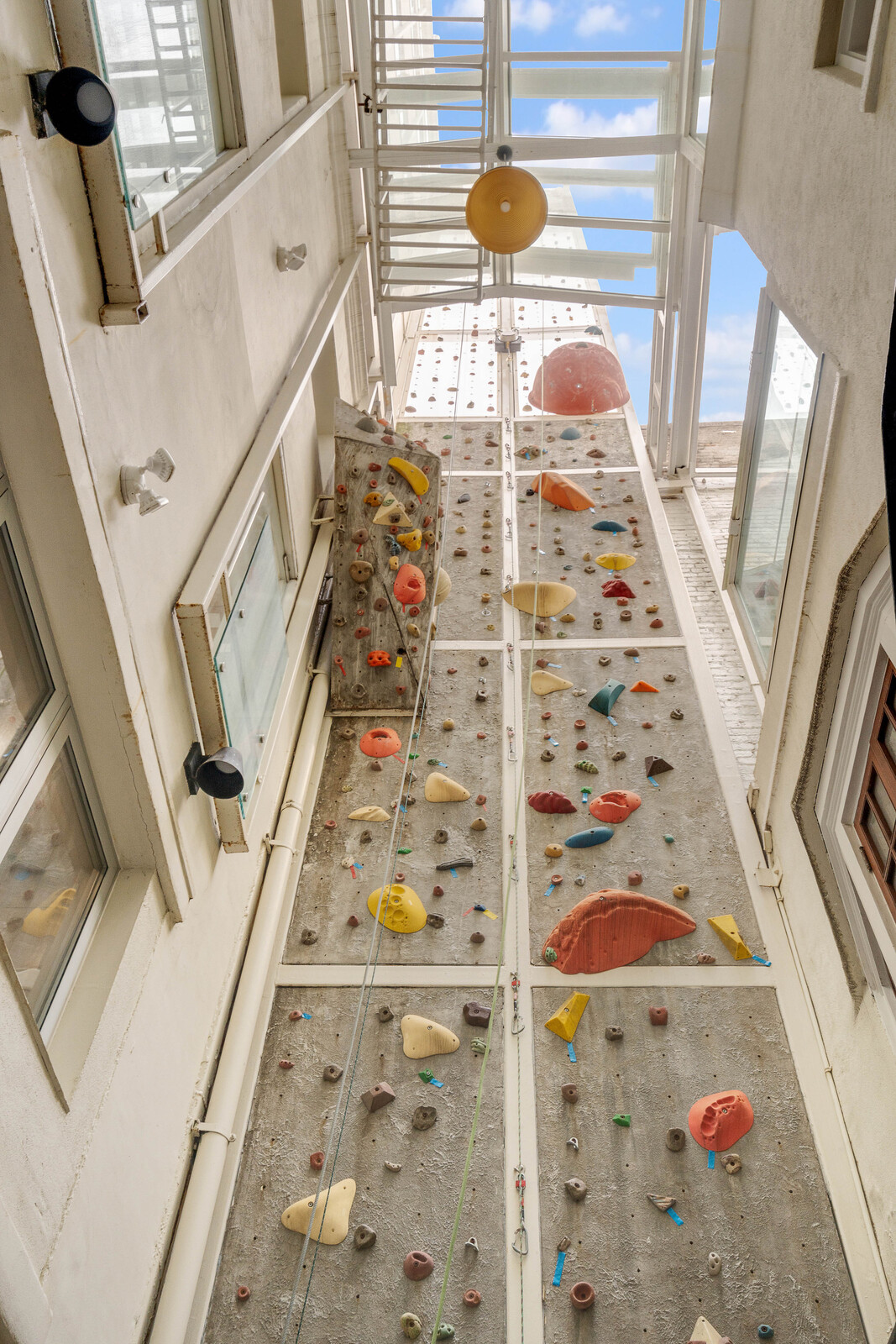 An 83-foot-high rock-climbing wall—complete with harnessing—sits between the two volumes.