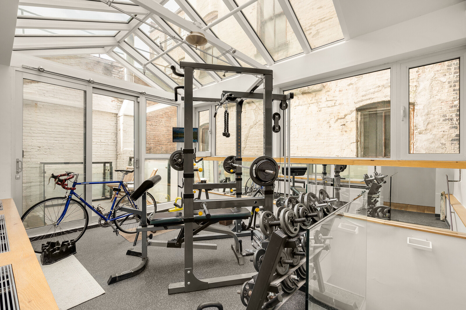 A fully equipped gym encased in glass awaits atop of the carriage house, across the courtyard.