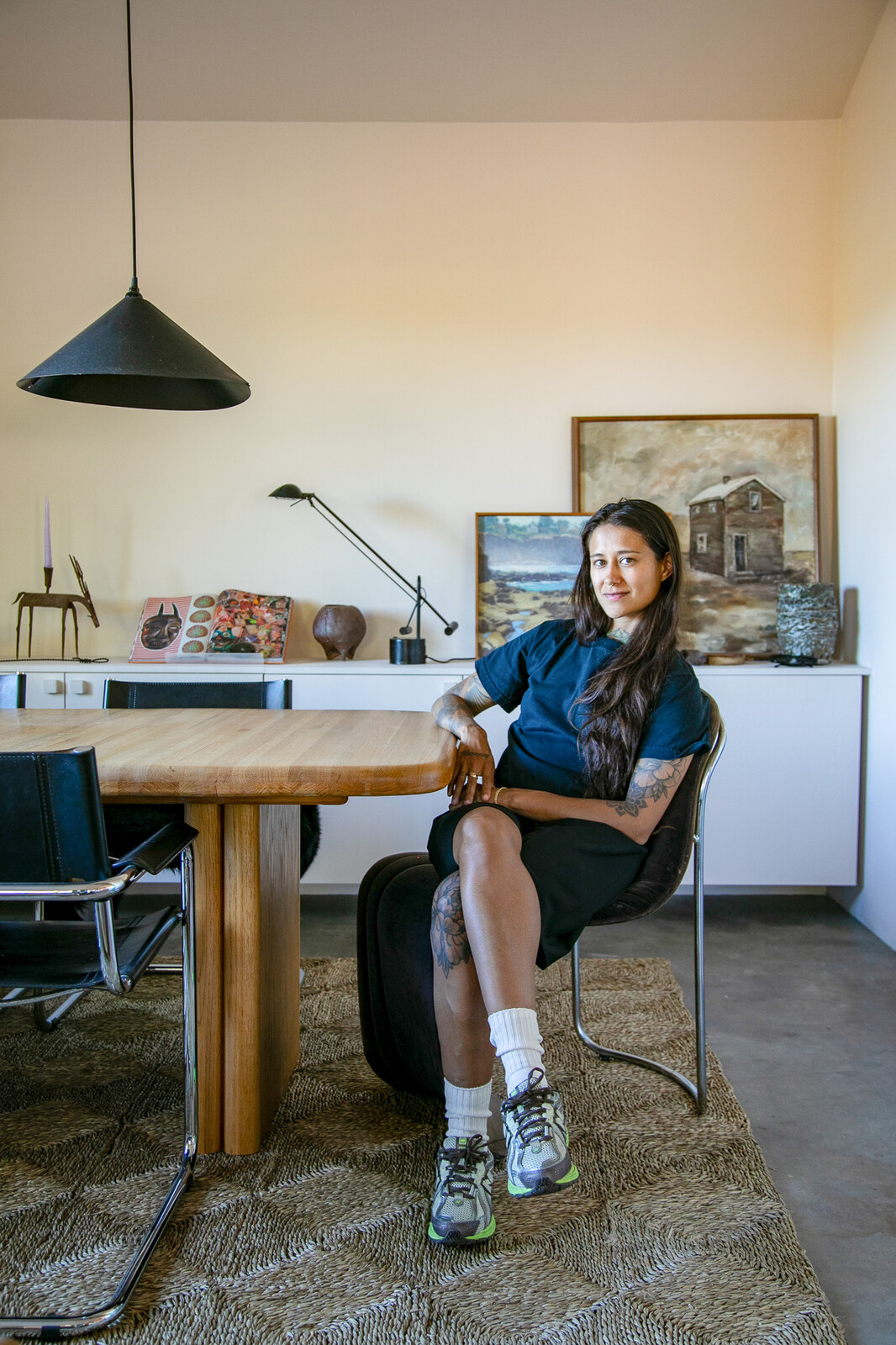 Catalina Monsalve sits at the dining table/workspace in the home’s bonus room.
