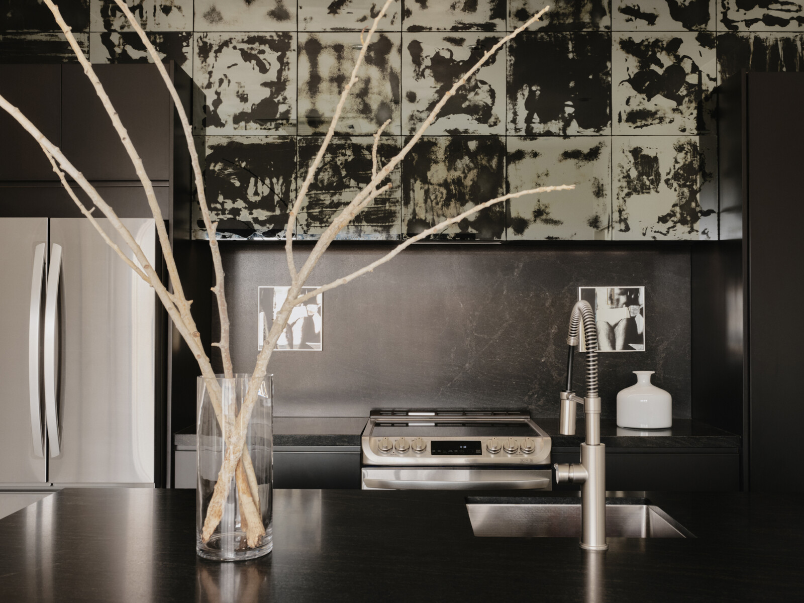 Salvare mirror prints act as a shimmering contrast in the all-black kitchen. <b>[Is Salvare a brand?]</b>