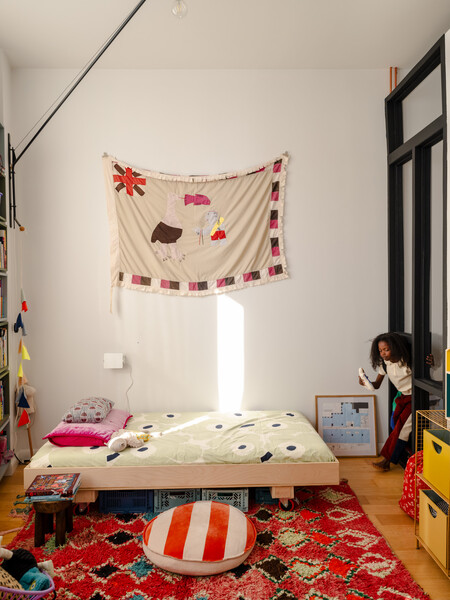 About a year after Cy was born, the couple turned the loft’s single large bedroom into two spaces—a combination office and nursery (below) and a bedroom for Phoenix, seen slipping between the two rooms through an opening that she likes to call the 
