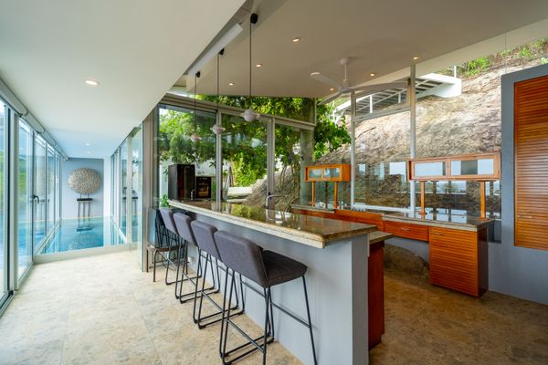 The hillside boulder supporting the home peeks through into the interior, seen here under the kitchen sink.