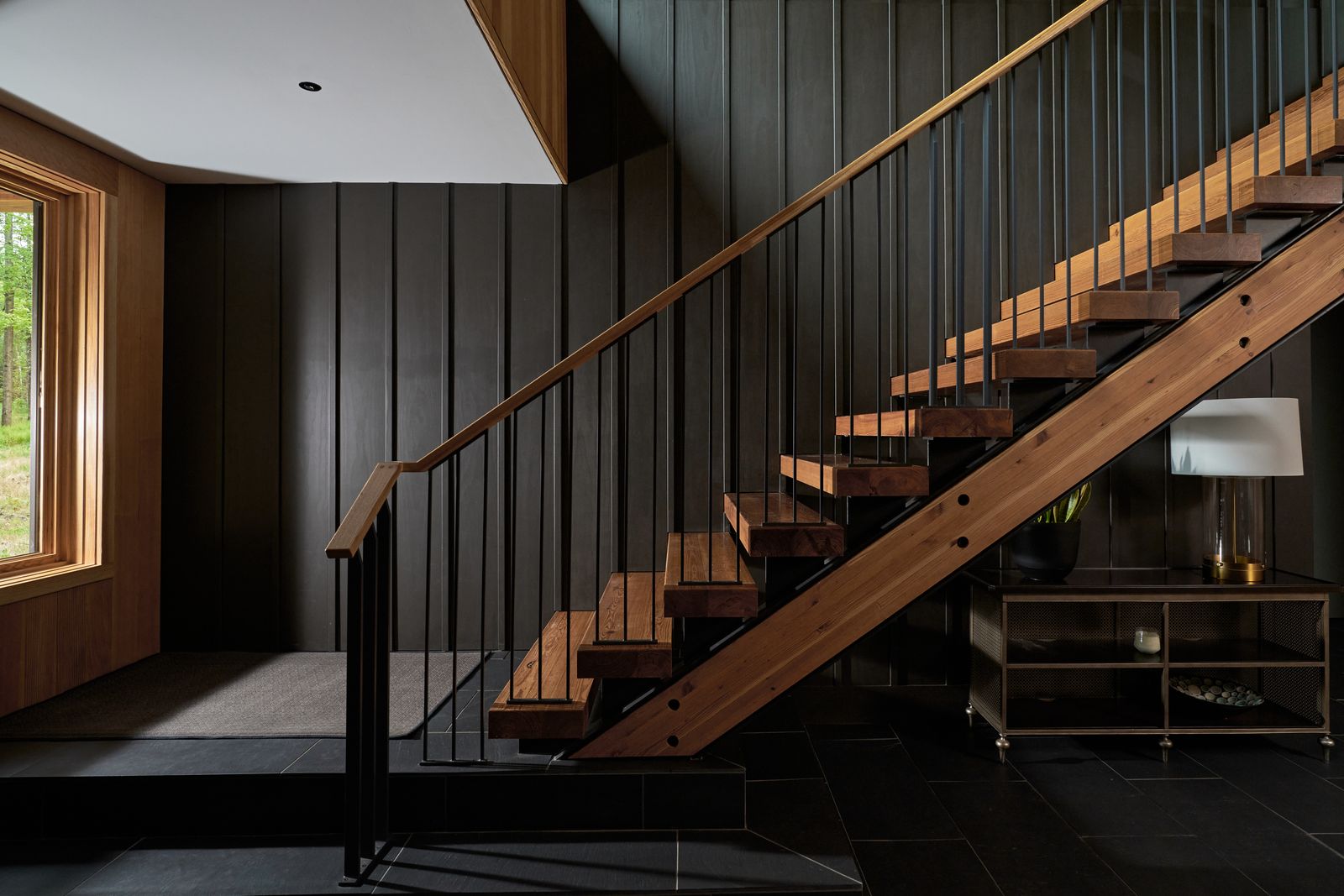 The sculptural, floating timber stair connects the home’s two volumes. Framed by exposed steel and lit from above, it creates a moment of weightlessness at the heart of the house.