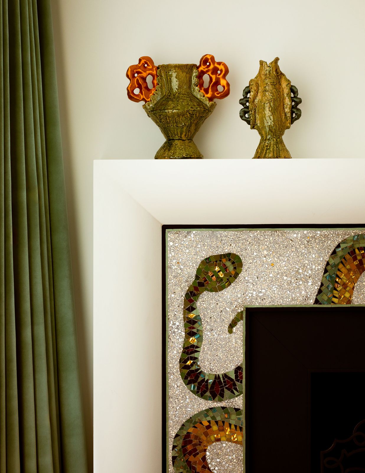 A close-up of the fireplace, with its slithery and sinuous snake that wraps around the border.