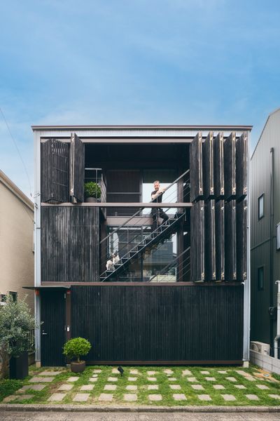 George and Mika Kougiadis downsized when they moved from a spacious apartment in Melbourne to a 925-square-foot townhouse in Tokyo. Yet the couple find their new home—with its facade of light-controlling shutters and warm, wood-lined interior—the perfect intimate setting for George’s art collection and their favorite furnishings.