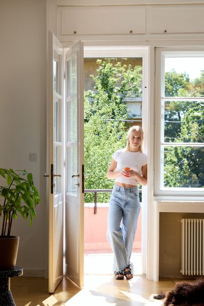 Designer Sarolta Hüttl stands in the living area of the 1930s apartment she revamped for her family in Budapest, Hungary.