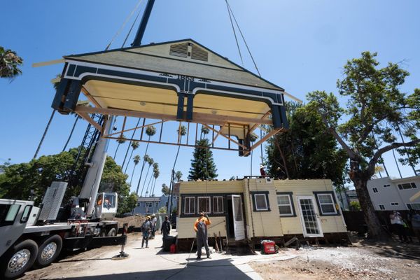 Construction workers prepare the Chambers couple’s 2,400-square-foot home for relocation.