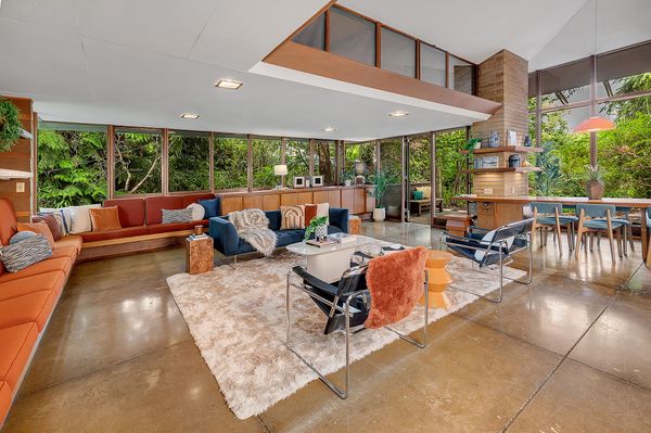 The living area is wrapped in glass and surrounded by built-in seating.
